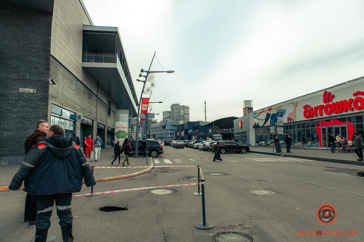 Яму оградили сигнальными лентами, а за ситуацией следят работники торгового центра