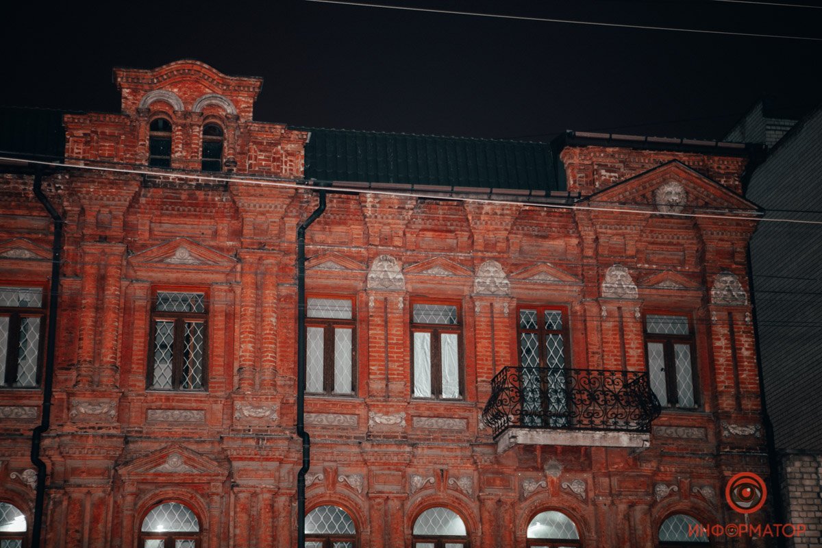 Красный фасад здания особенно выделяется на этой улице
