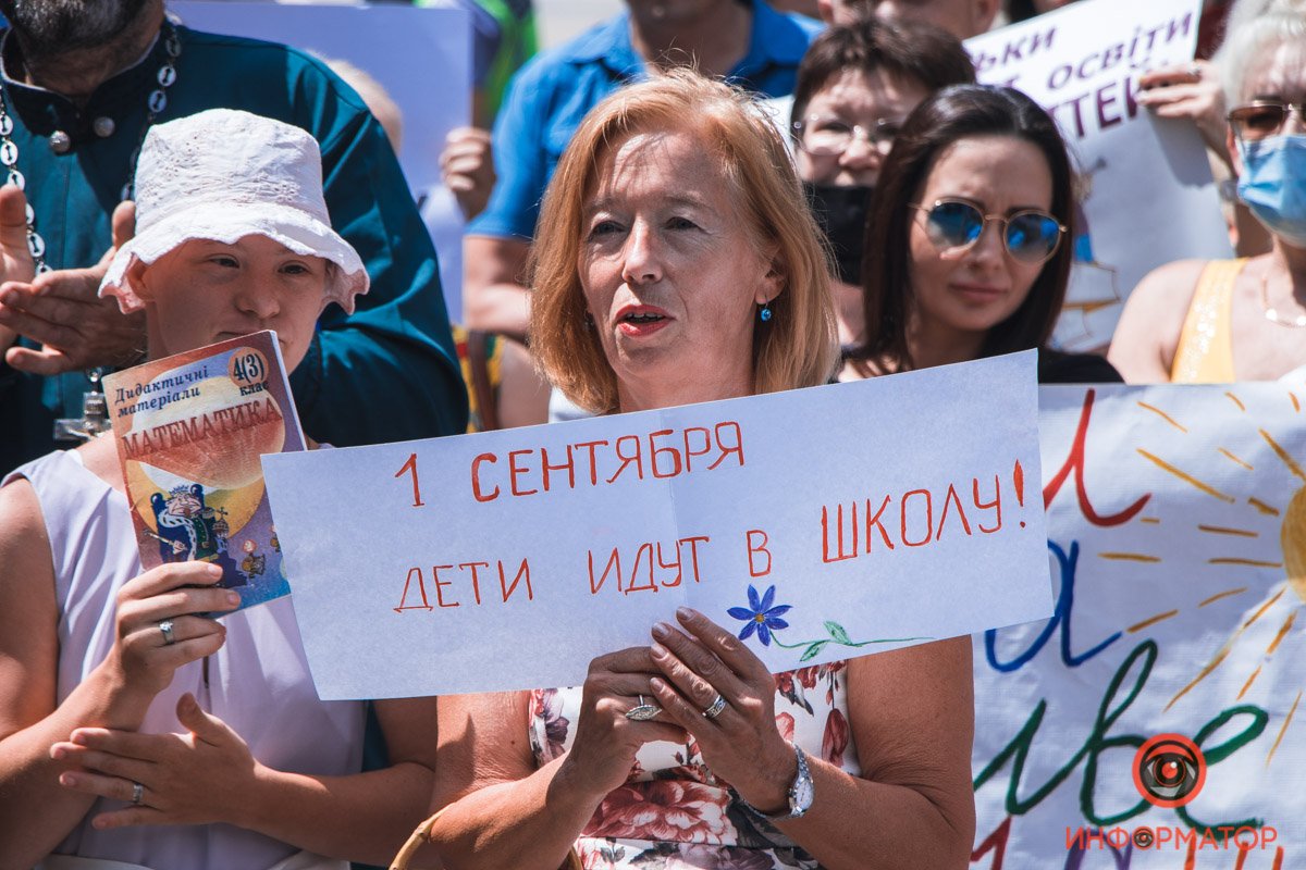 Люди держали в руках плакаты и учебники