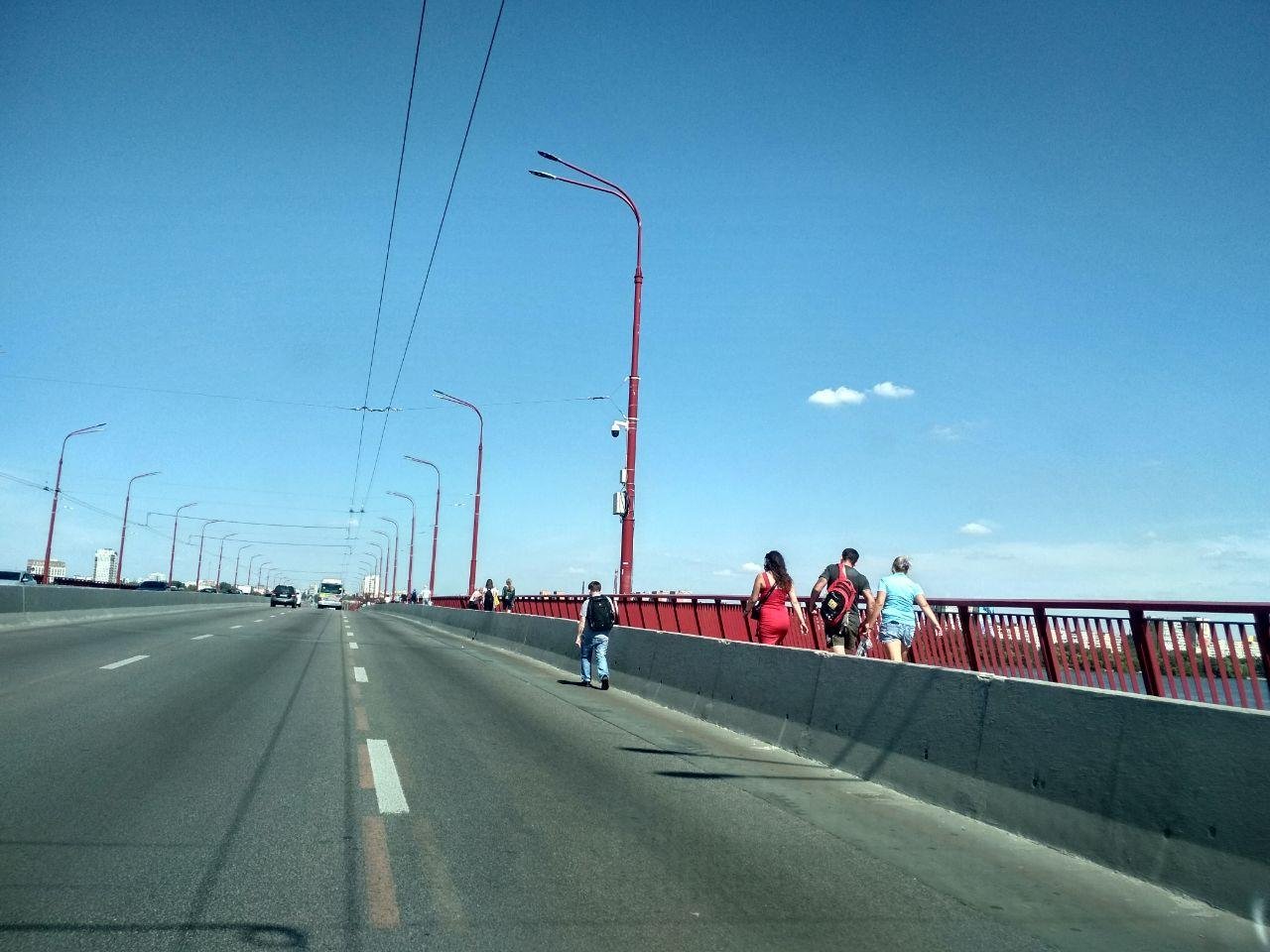 Люди идут по мосту