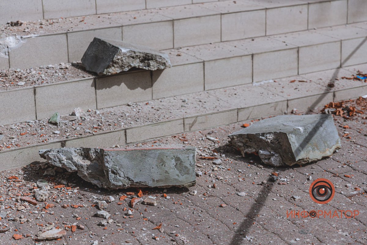Фрагменты стен летят на ступени, ведущие ко входу в здание