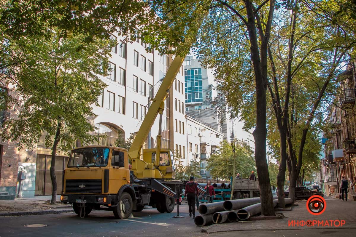 Коммунальщики выгружают трубы