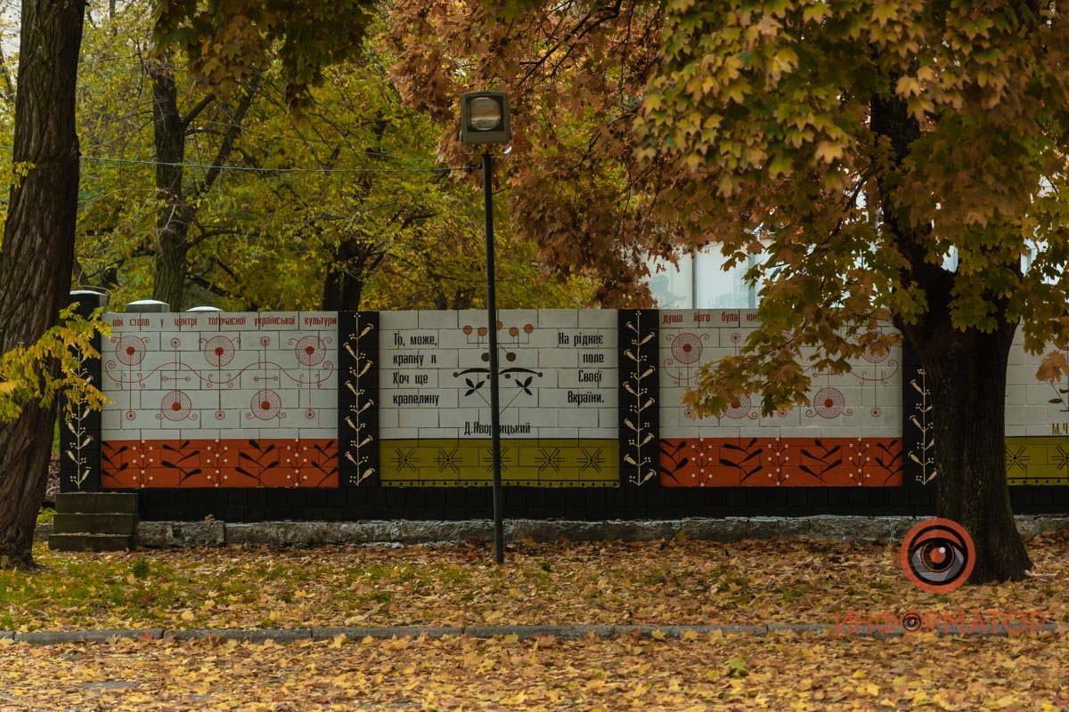 Слева, напротив трамвайной остановки