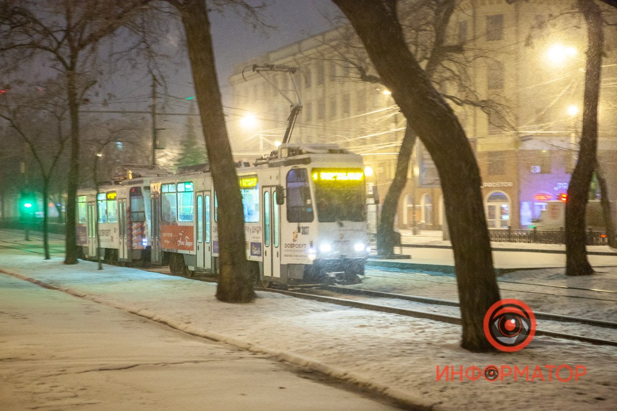 Снежинки красиво летят в свете уличных фонарей и фар Снежинки красиво летят в свете уличных фонарей и фар