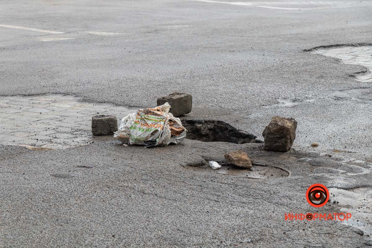 Яму оградили брусчаткой и строительным мусором