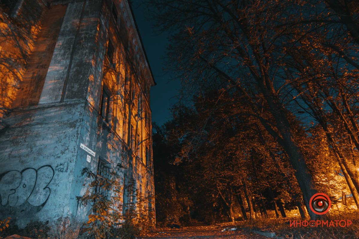 И только тень от фонарей освещает фасад заброшенного здания 