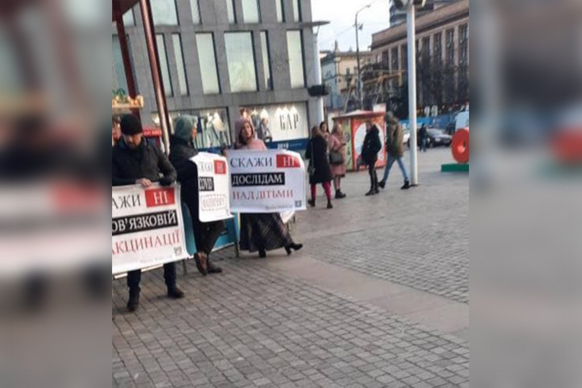 Они держали плакаты с надписями "Скажи "нет" COVID-фашизму", "Скажи "нет" опытам над детьми" и "Скажи "нет" обязательной вакцинации".