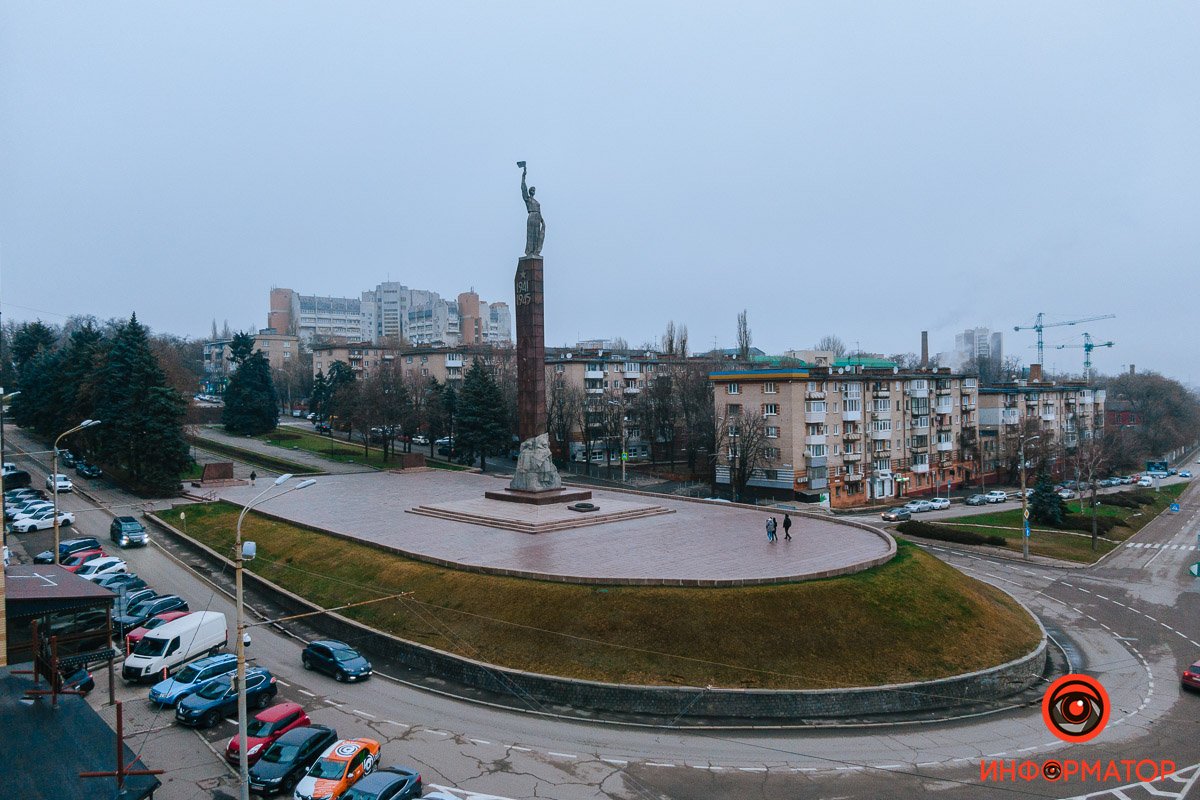 Она держит факел и пальмовую ветвь - символы свободы и памяти