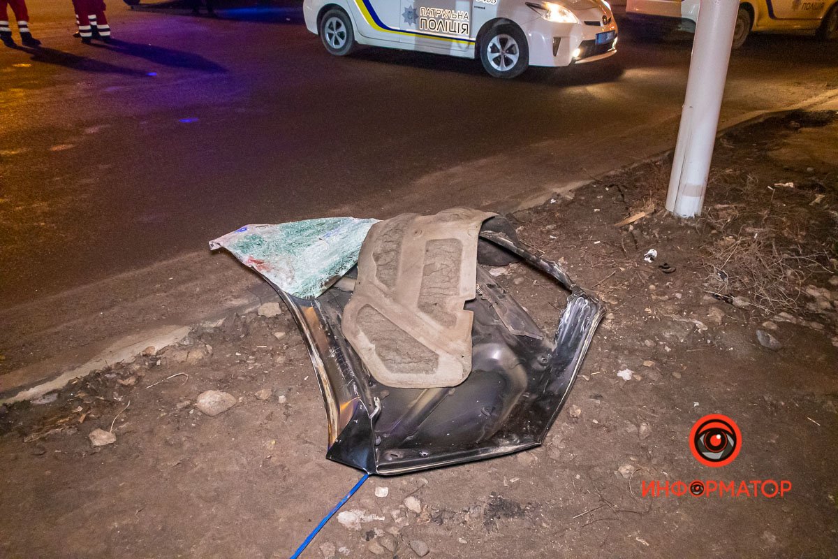 Стекло и детали машины разбросаны по дороге и тротуару 