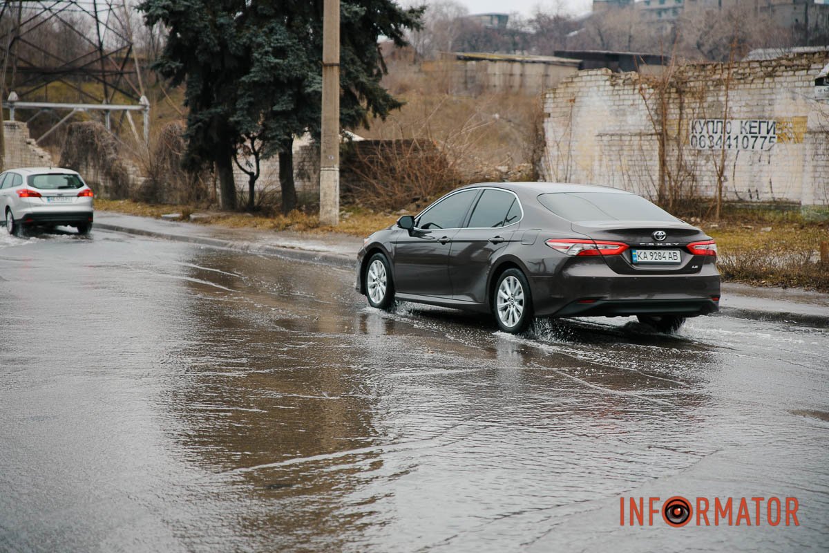 Автівка проїждає по затопленій дорозі Автівка проїждає по затопленій дорозі