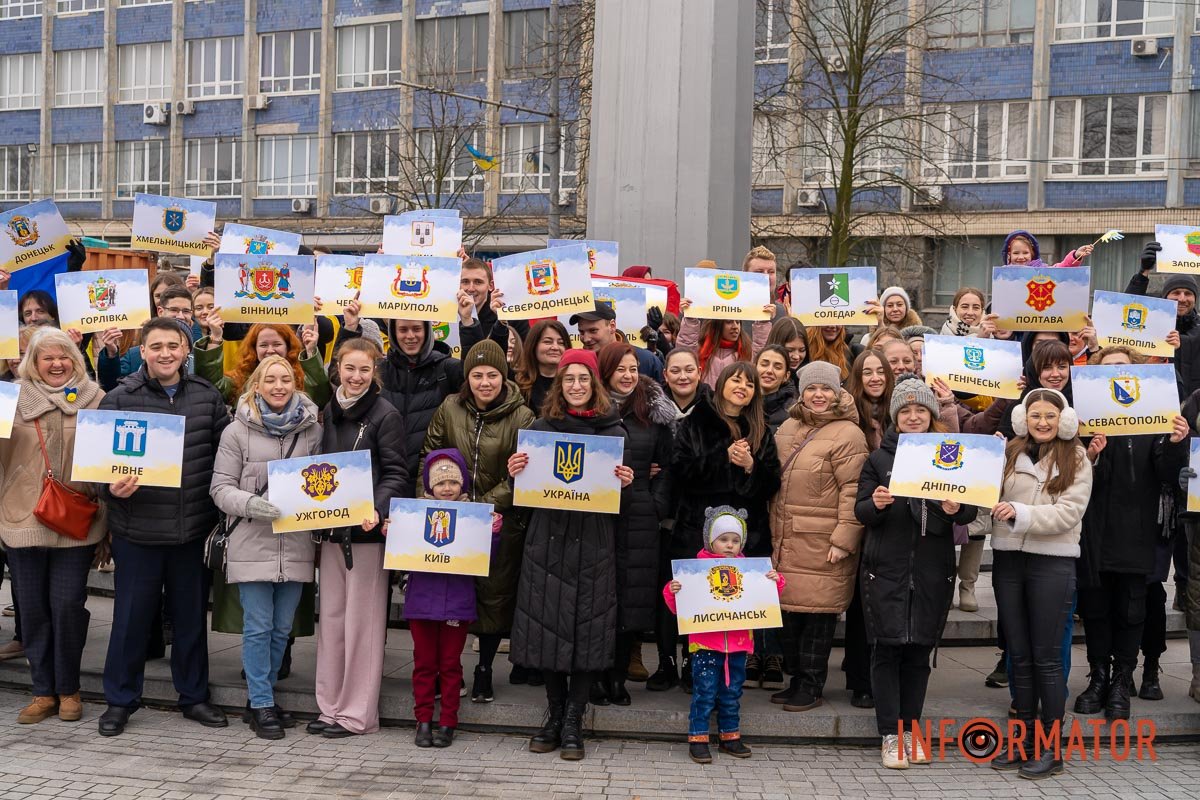 Хлопці та дівчата тримали в руках таблички з назвами українських міст Хлопці та дівчата тримали в руках таблички з назвами українських міст