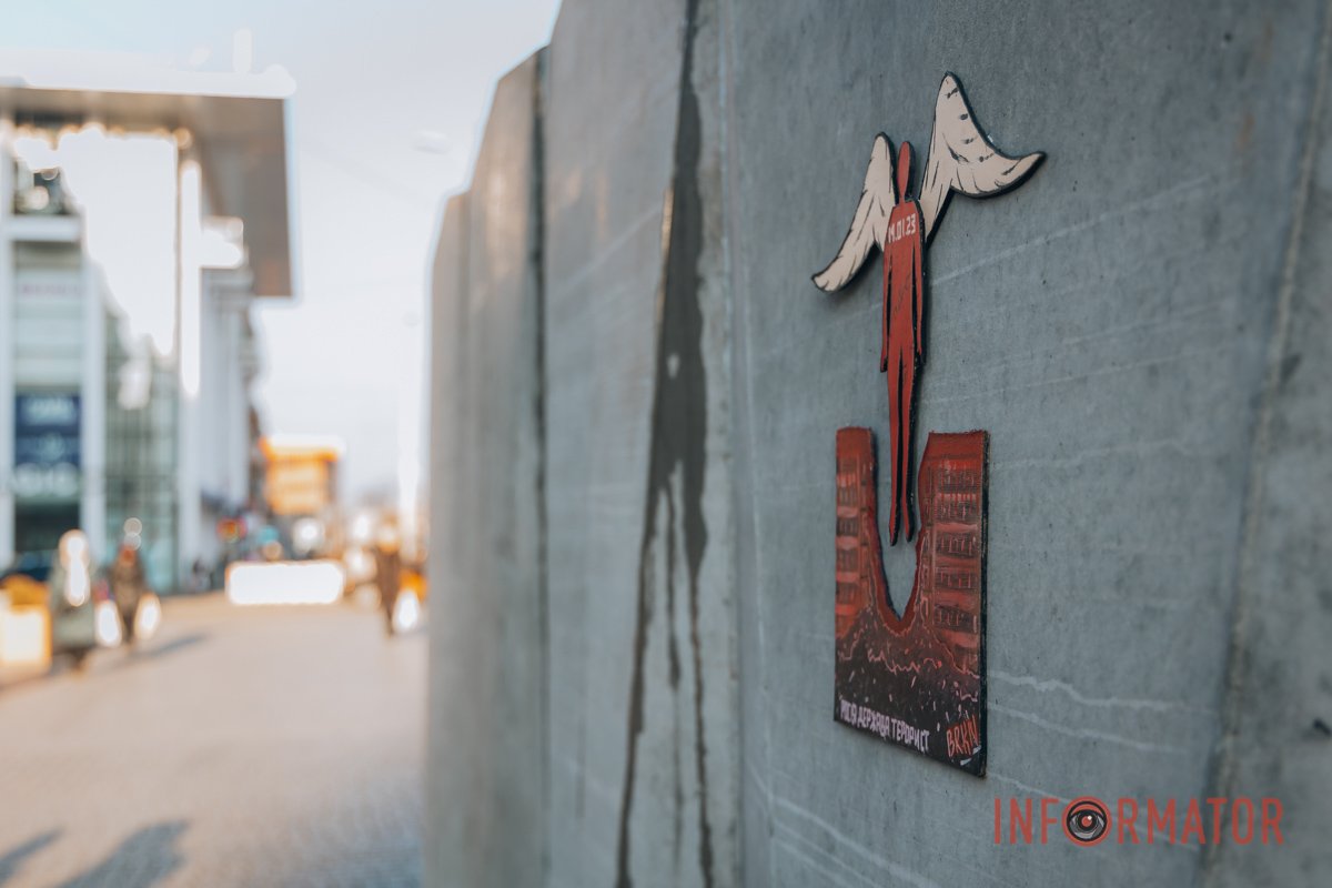 Зруйнований будинок, над яким постає червона людина з крилами Зруйнований будинок, над яким постає червона людина з крилами