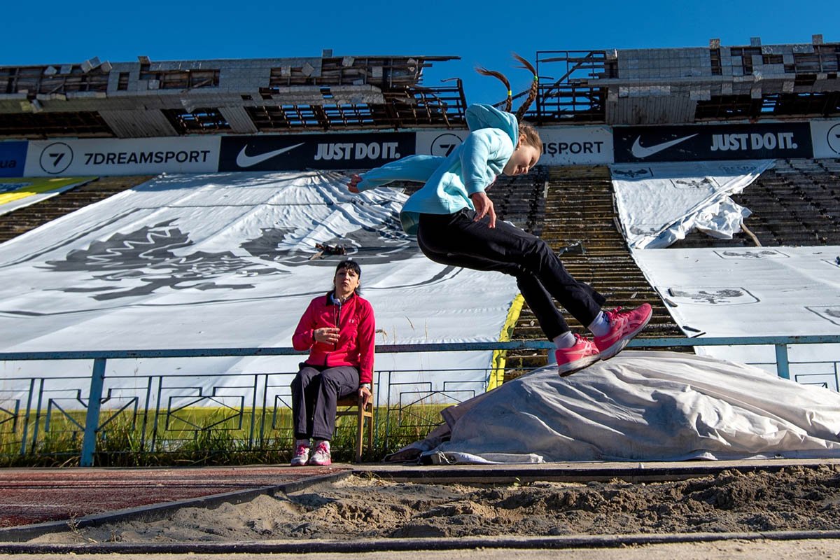Легка атлетика. Дівчинка стрибає у довжину на зруйнованому стадіоні у Чернігові. Легка атлетика. Дівчинка стрибає у довжину на зруйнованому стадіоні у Чернігові.