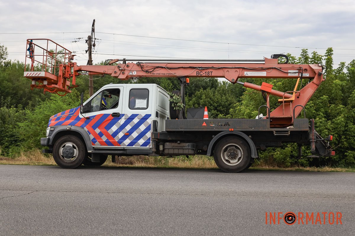 Комунальники оглядають пошкоджений стовп