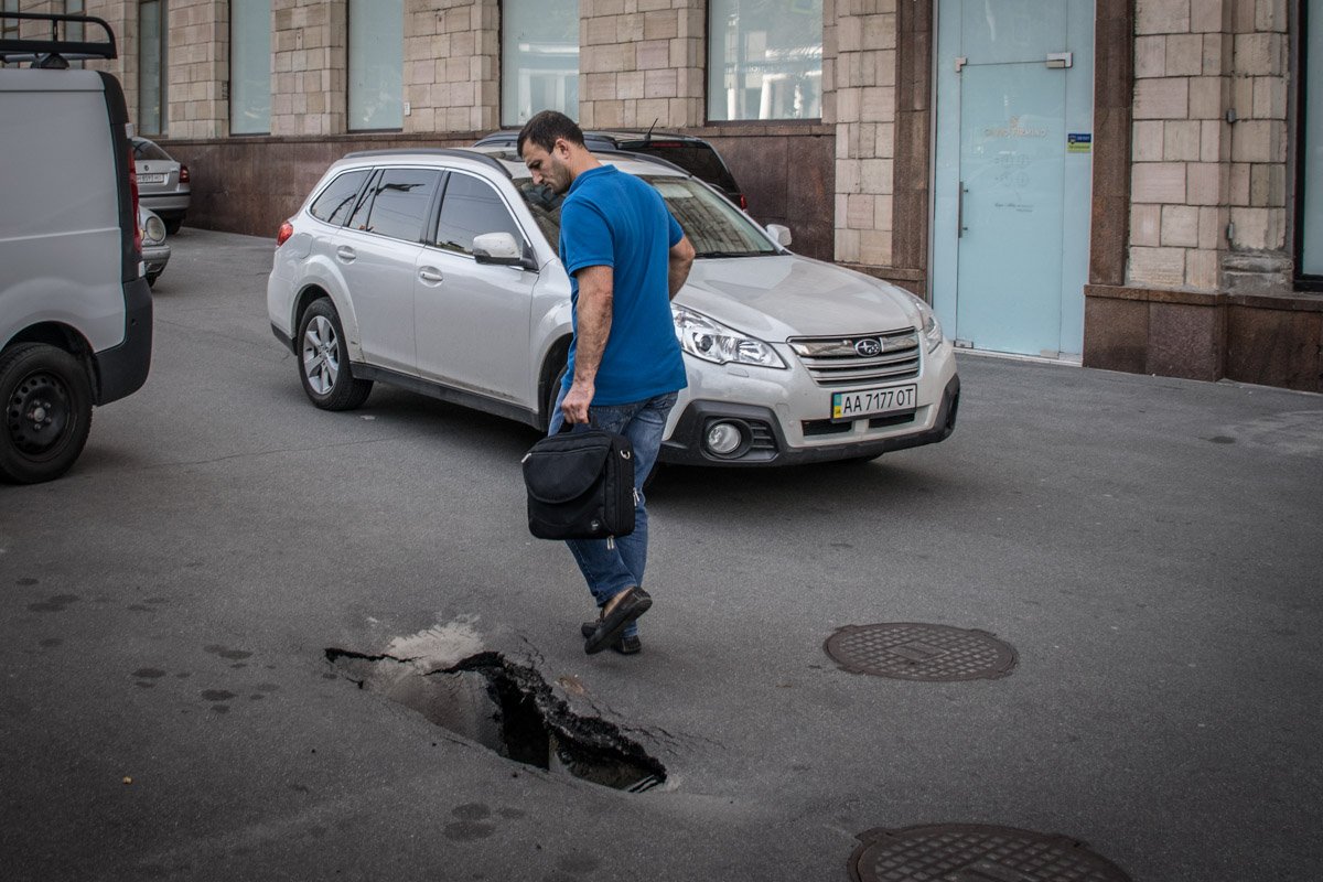 Киевляне обходят пролом в асфальте стороной
