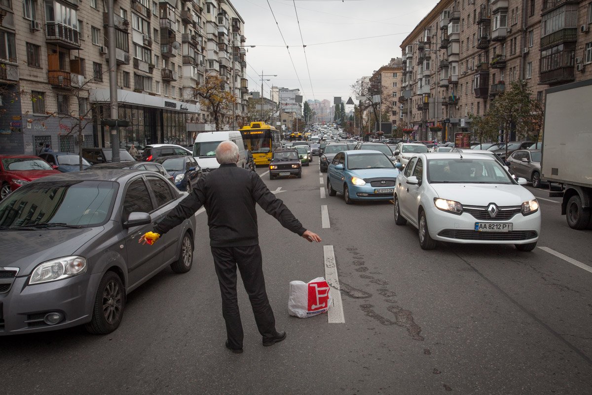 Один из участников аварии регулирует движение на месте столкновения четырех автомобилей