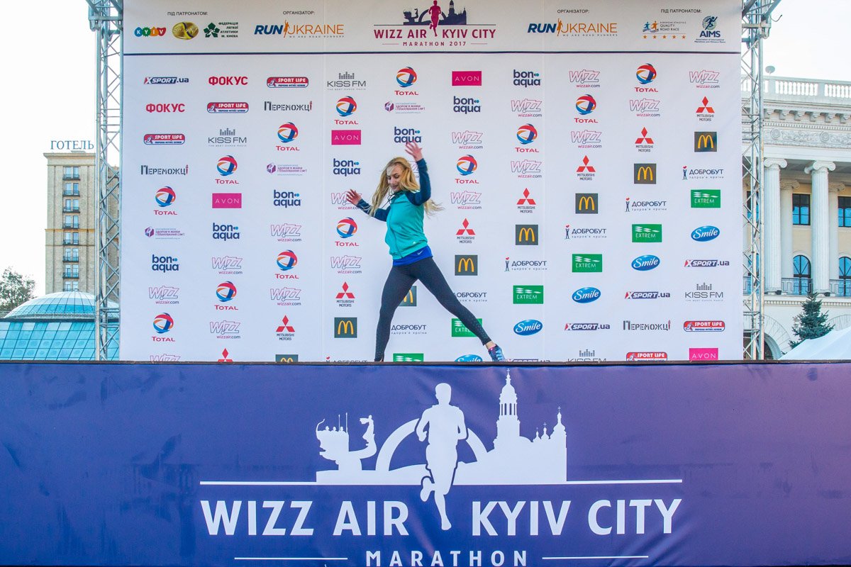 Тренер на сцене показывала базовые движения для разминки перед забегом