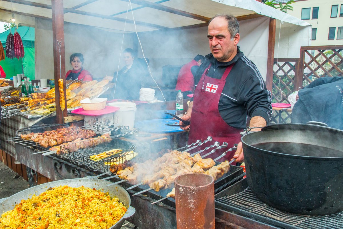 Грузинские повара продают мясо и традиционные блюда с огня