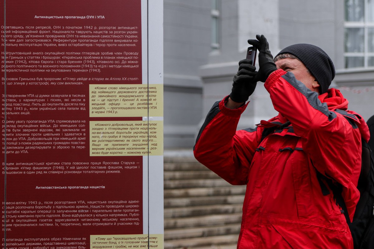 Мужчина фотографирует интересный факт на стенде