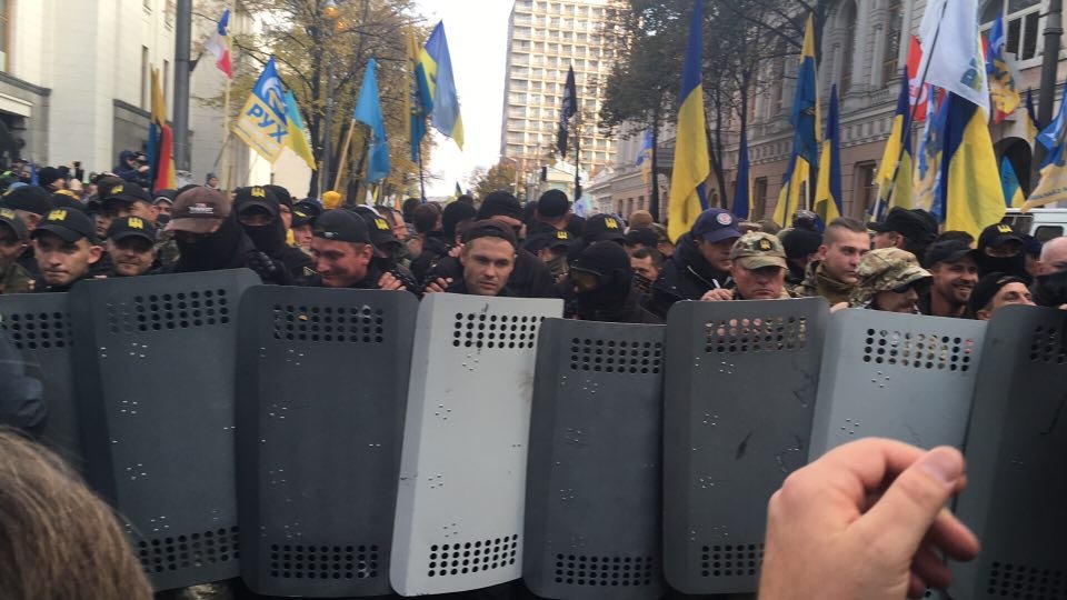 Бойцы "Донбасса" и "Айдара" со щитами. Помогают людям проносить палатки к зданию Рады. Они идут "задним ходом", защищая обычных митингующих от воздействия полиции