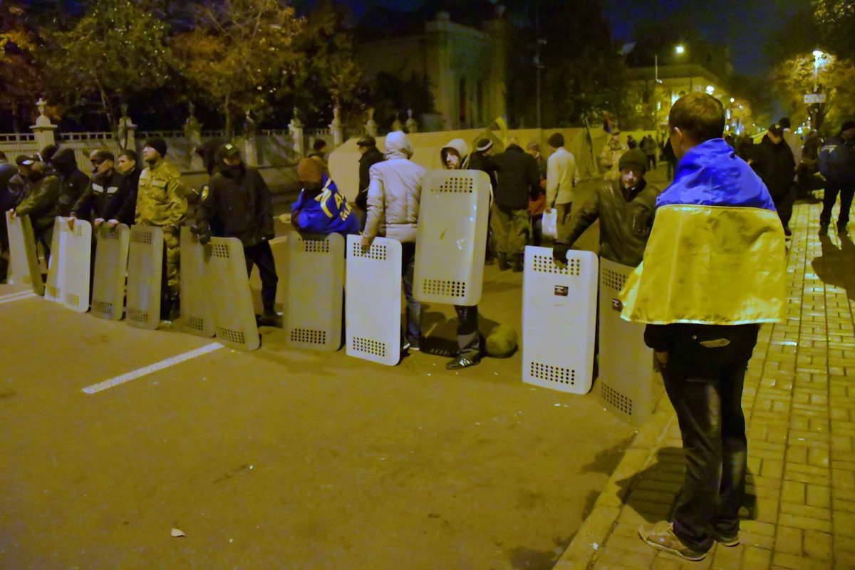 Несмотря на позднее время, митингующие стоят возле Рады со щитами