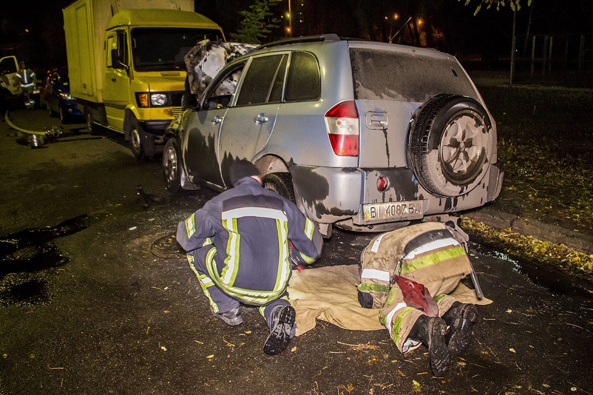 Спасатели осматривают сгоревшее авто