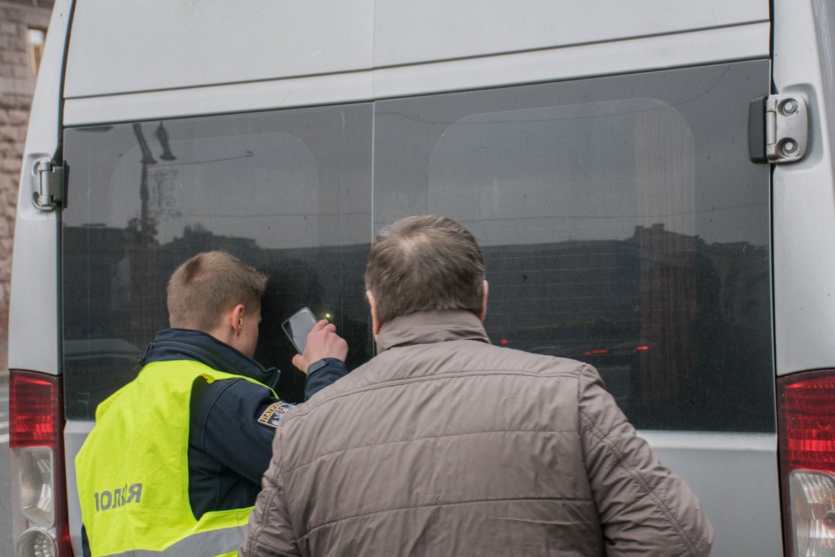В одном из микроавтобусов не открывалась задняя дверь, поэтому полицейский использовал фонарик, чтобы посмотреть, что находится в машине 