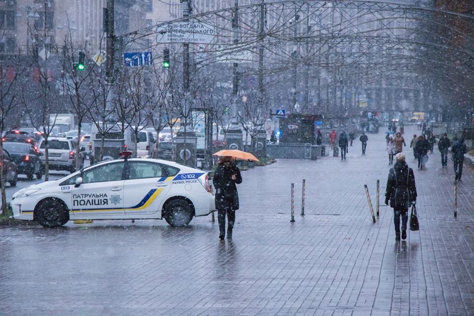 Некоторые спасаются от снега с помощью зонтов