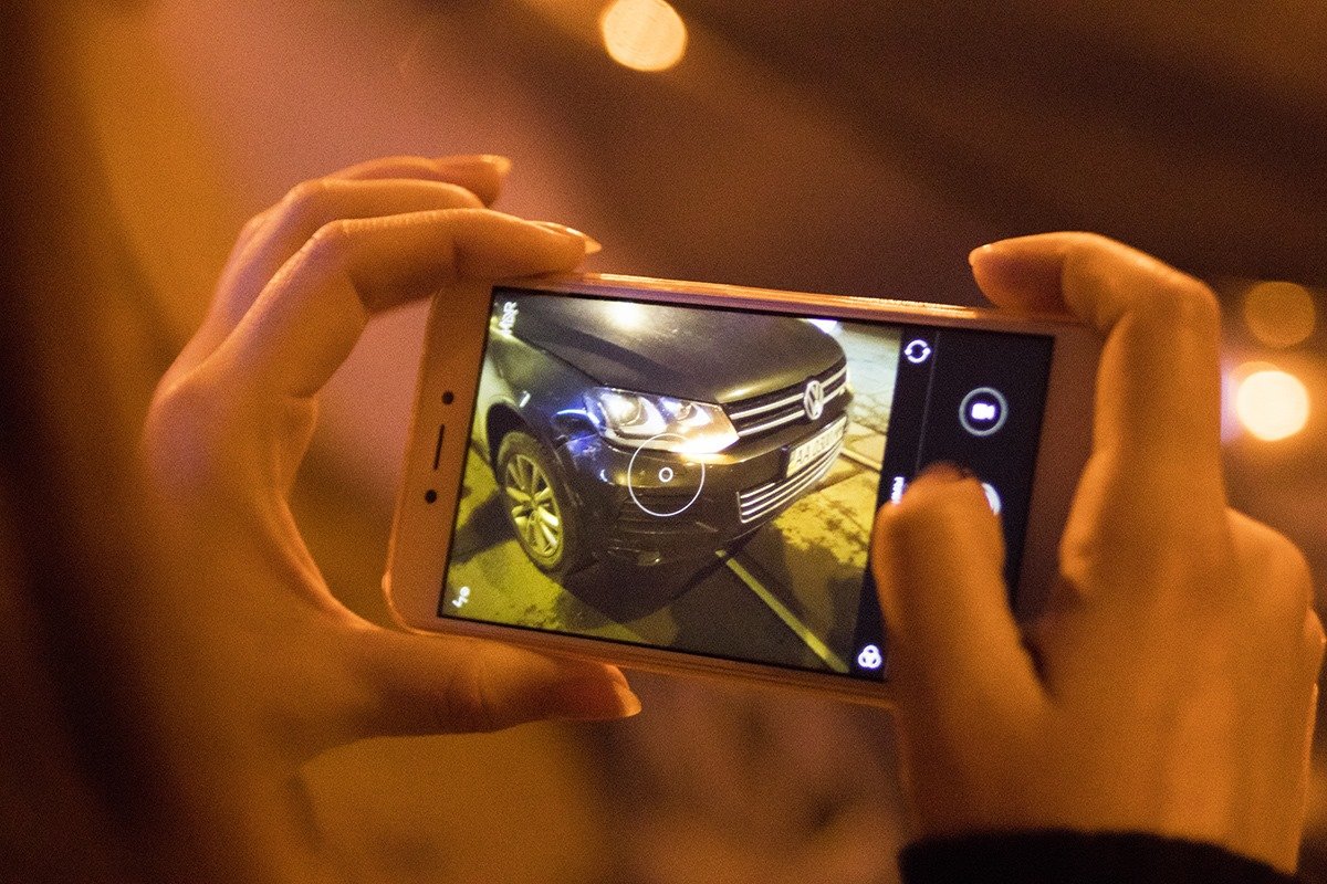 Девушка фотографирует повреждения на своей машине