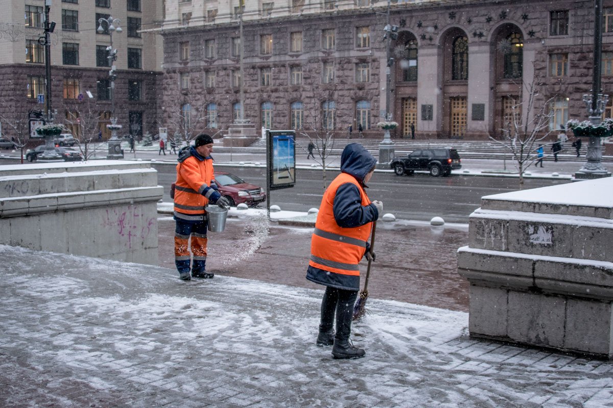 Коммунальщики убирают снег и посыпают тротуары специальной смесью