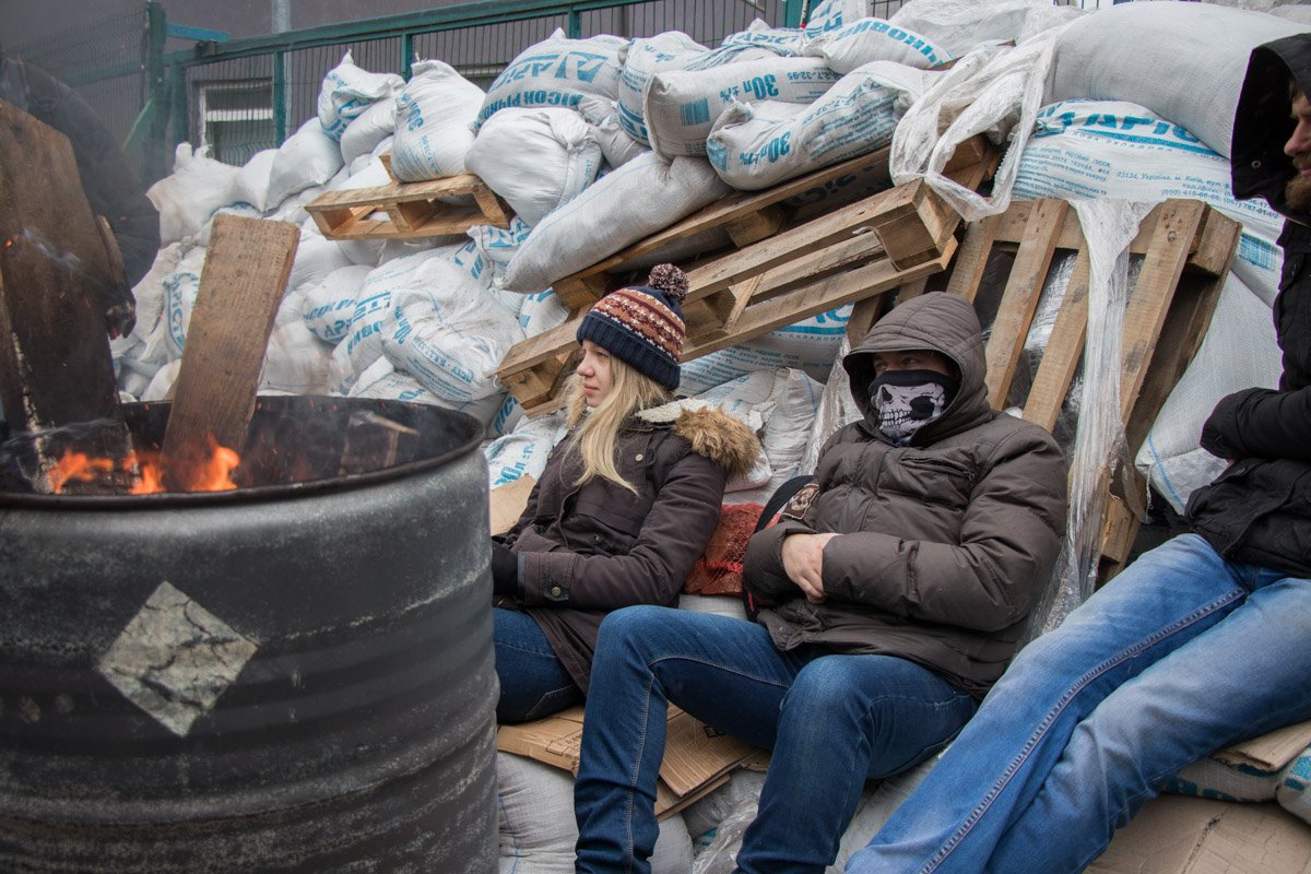 Активисты греются у огня, разведенного в бочке Активисты греются у огня, разведенного в бочке