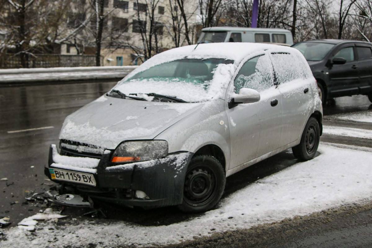 Рядом с Chevrolet разбросаны разбитые части авто после столкновения