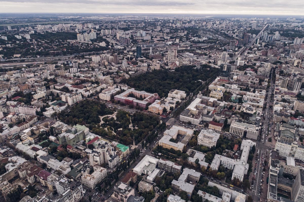 Зеленые островки на фоне серых зданий и серых туч