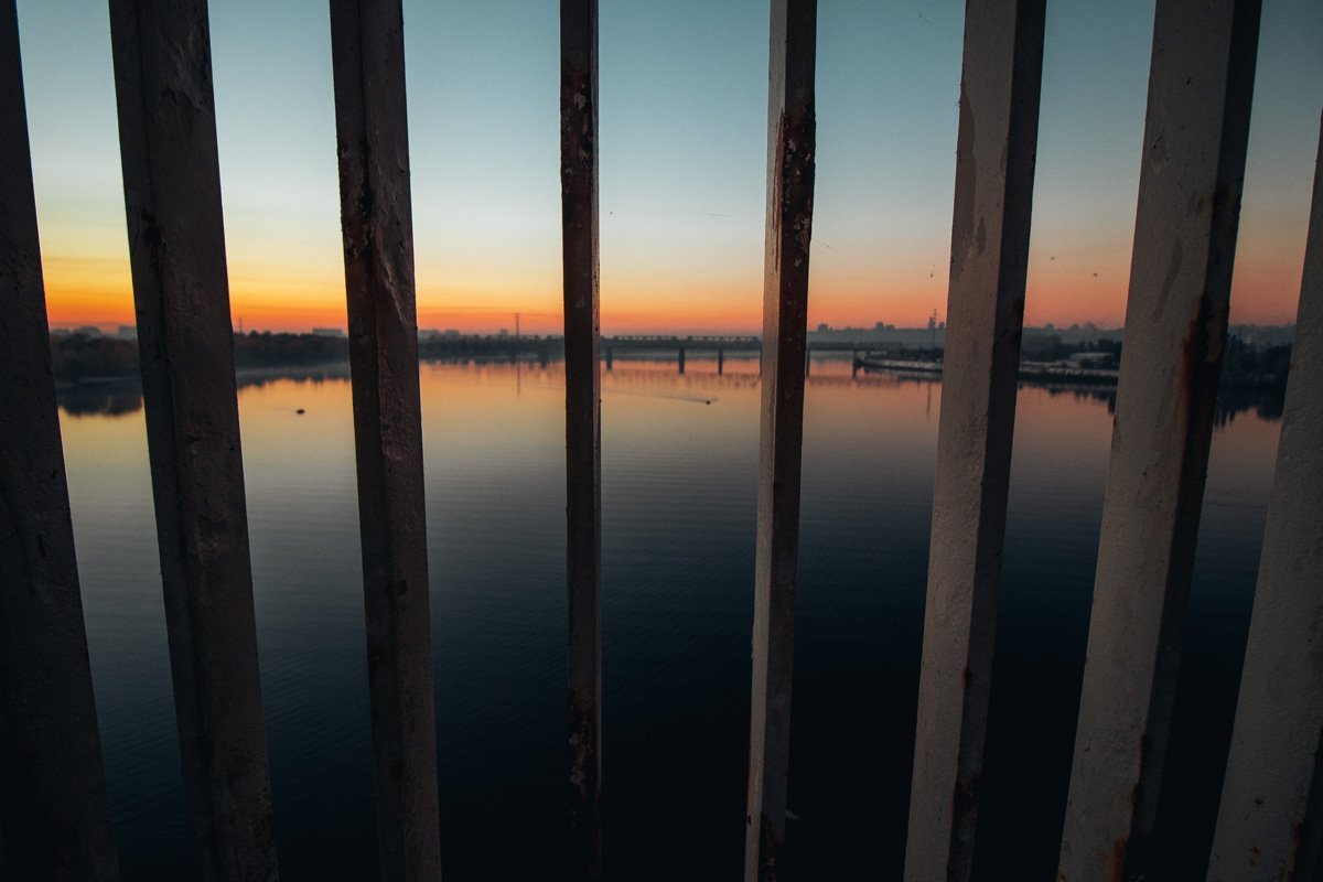 Сквозь перила моста можно увидеть чарующий рассвет 