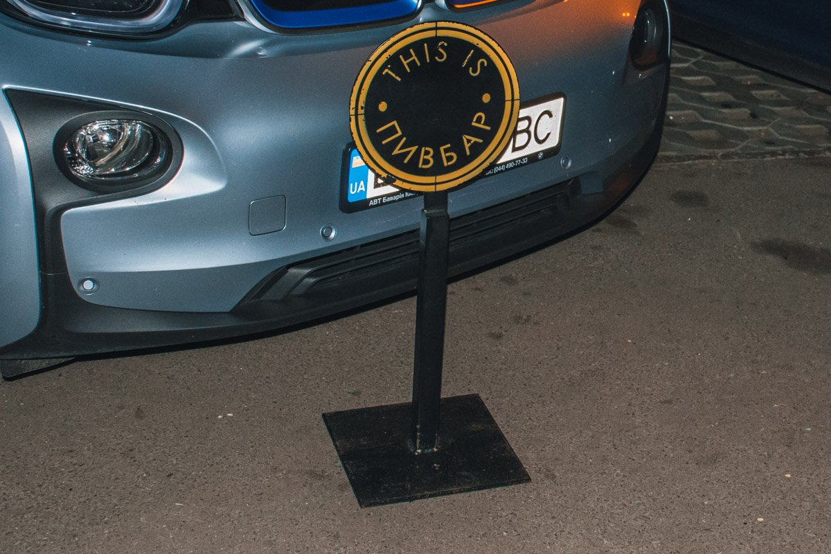 Этим столбиком один из мужчин разбил лобовое стекло рядом стоящей машины