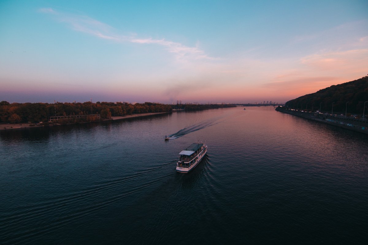 Уходящий теплоход плывет в закат выходного дня