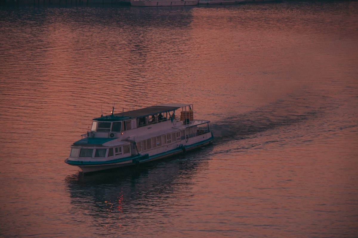 Лишь теплоход разбивает гладкую поверхность воды
