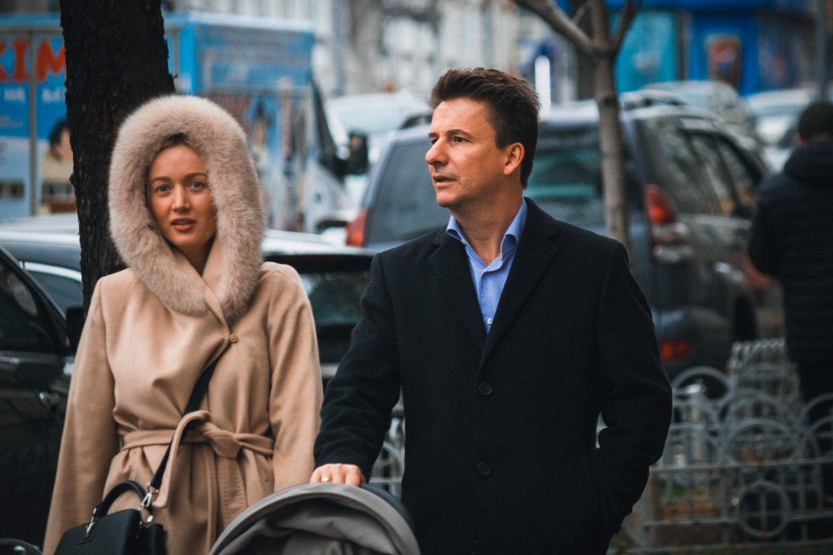 Милые молодые семьи хорошенько утеплились и гуляют со своими малышами по центру шумной столицы