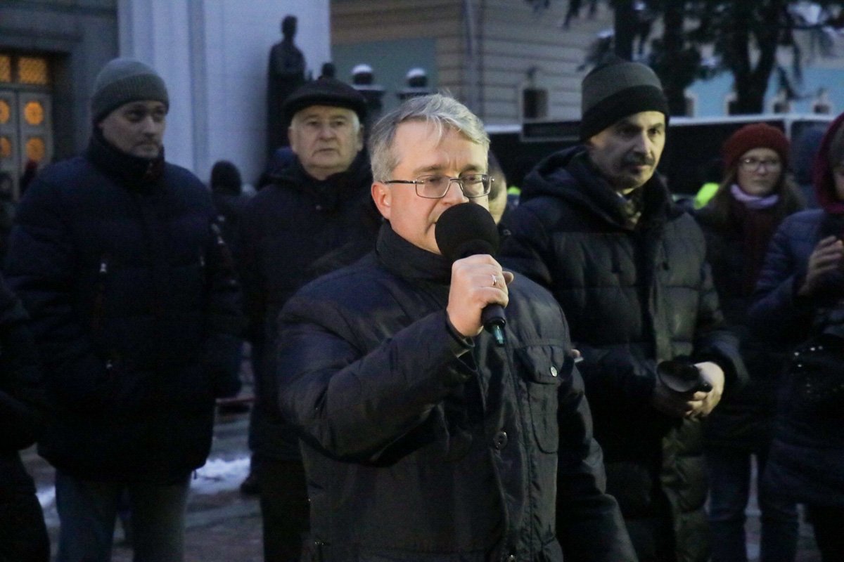 Активисты стоят под зданием с транспарантами и флагами, настроены они достаточно агрессивно даже по отношению друг к другу