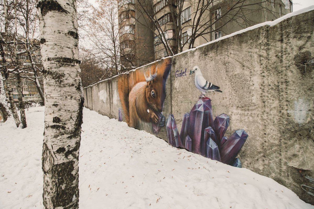 На невзрачном заборе на территории детского сада №680 по адресу улица Гродненская, 11А поселилась милая белочка с короной, которая грызет кристалл - аметист На невзрачном заборе на территории детского сада №680 по адресу улица Гродненская, 11А поселилась милая белочка с короной, которая грызет кристалл - аметист