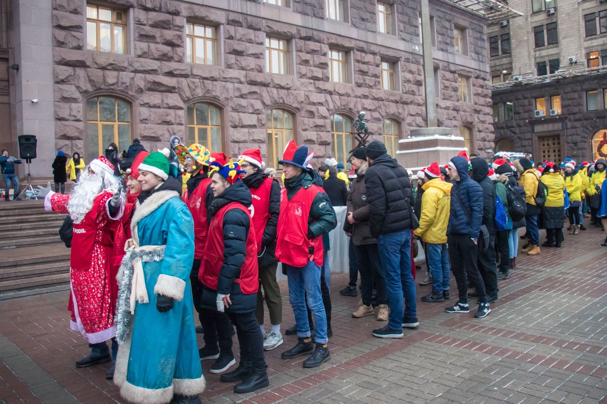 У здания КГГА собрались около сотни скаутов и волонтеров, которые поздравляли жителей и гостей столицы с Днем святого Николая