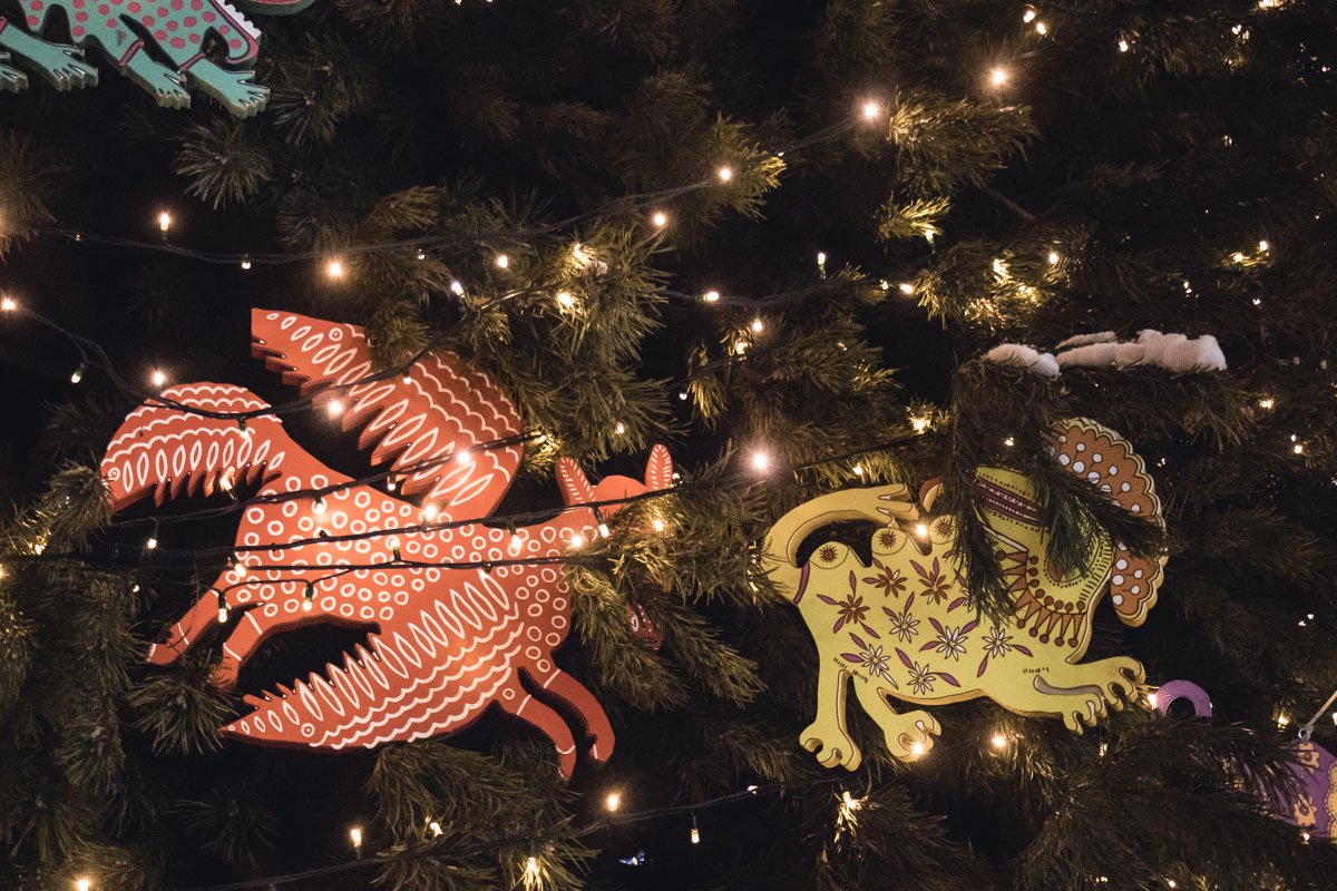 Большие и красочные птицы, львы и загадочные существа смотрят на прохожих с елки