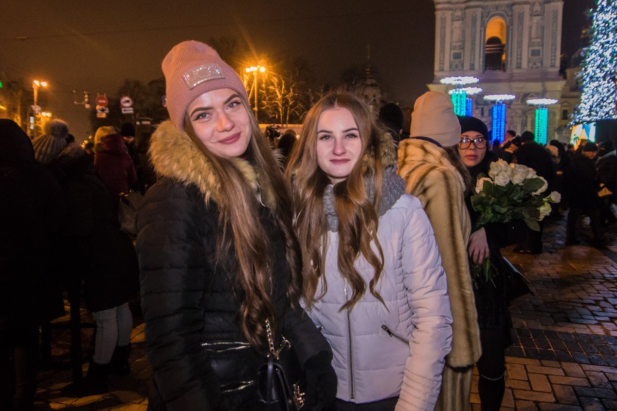 Счастливые лица в окружении новогодних гирлянд 