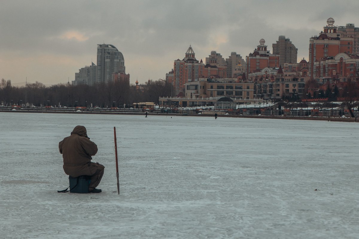 Одинокий рыбак любуется зимним пейзажем Одинокий рыбак любуется зимним пейзажем
