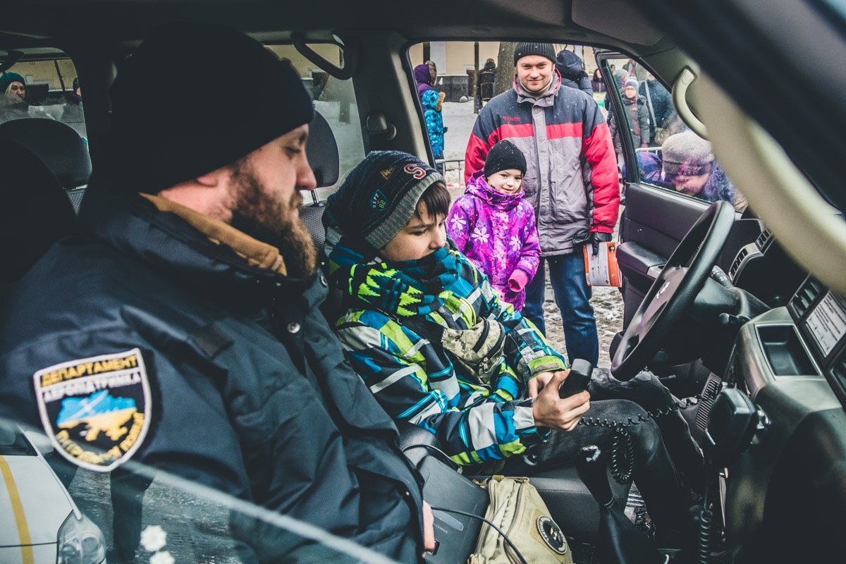 Патрульные катают маленьких детей на полицейских машинах с включенными мигалками и сиренами