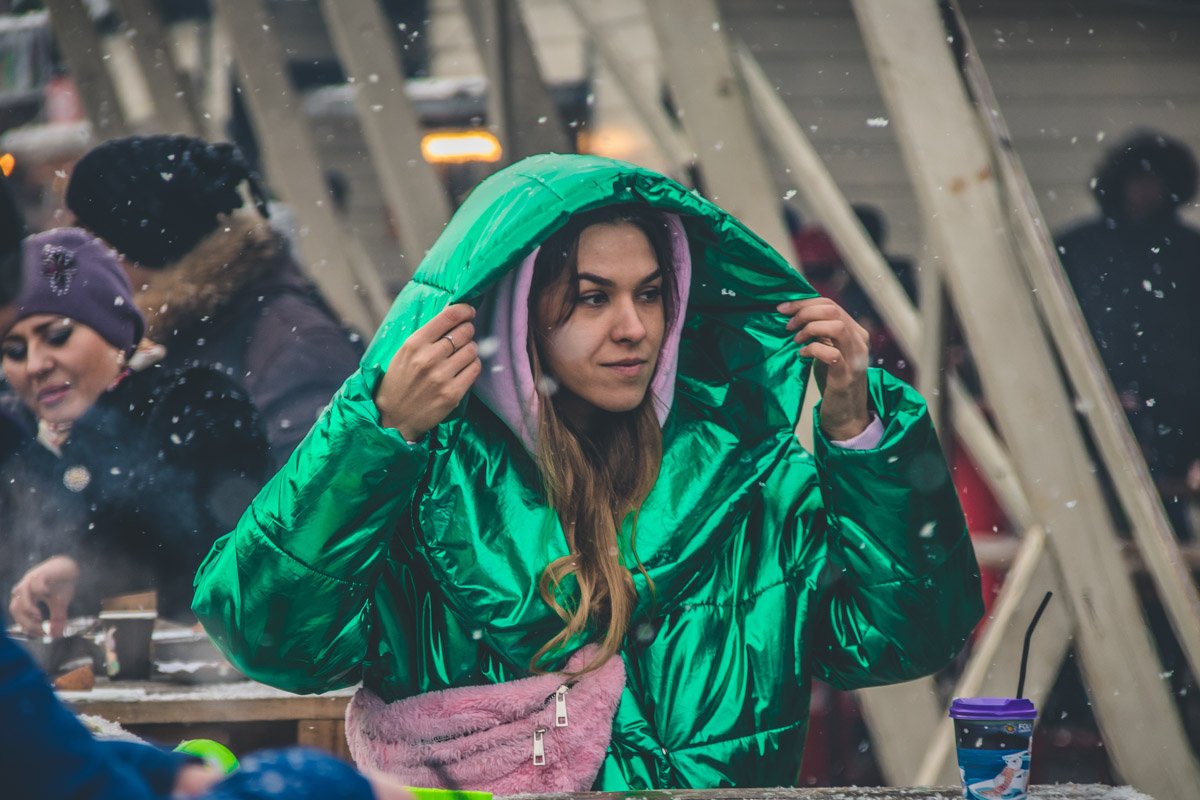 Прячется от снега, с любопытством изучая прохожих Прячется от снега, с любопытством изучая прохожих