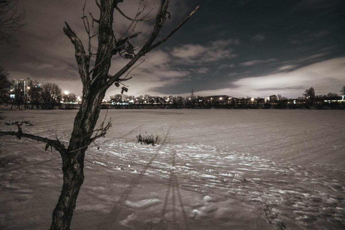 Лишь огни города вдалеке разбавляют белую мглу ночного озера