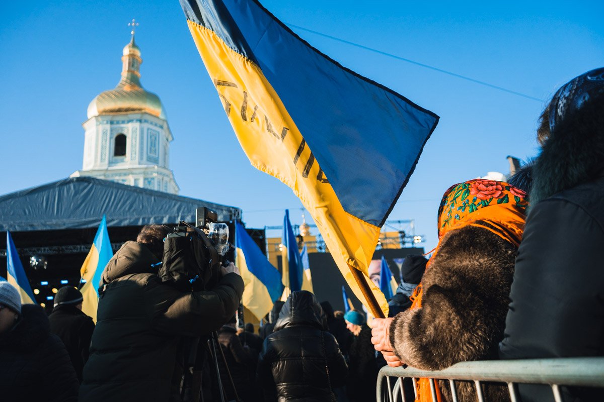 Люди торжественно держат флаги своей страны