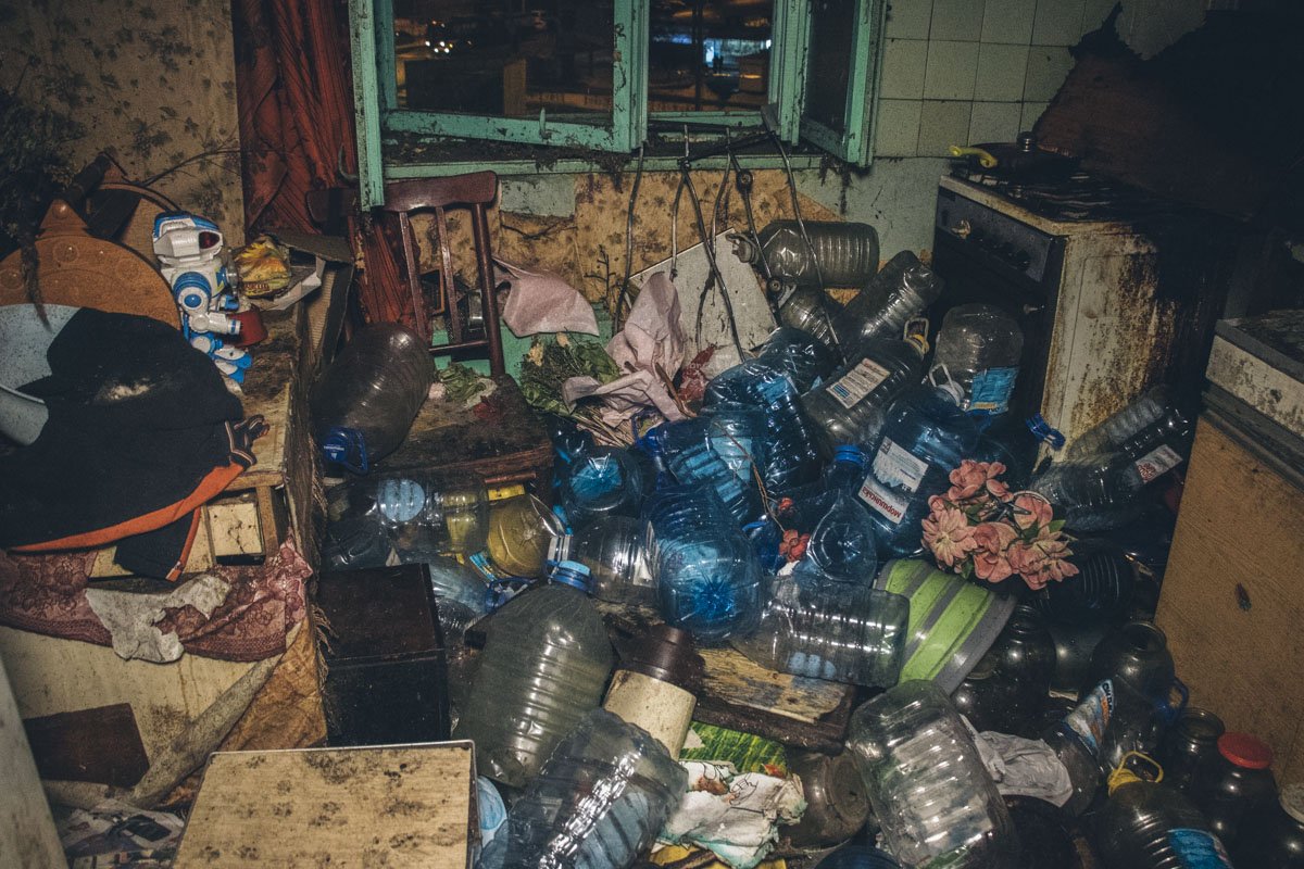 В заваленной мусором квартире из-за огромных долгов нет света и газа