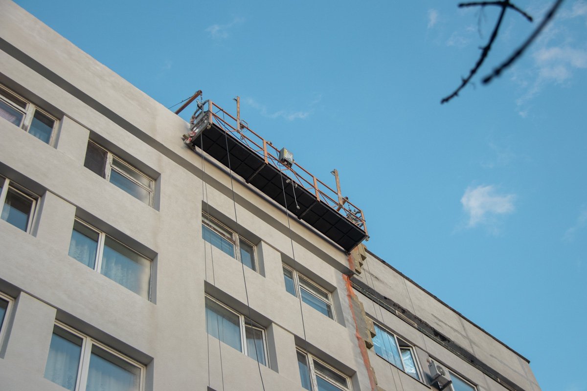 Бригада рабочих в составе троих человек, находилась в люльке на втором этаже здания